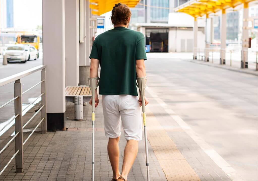 business-task-completion rear view of man using crutches to walk
