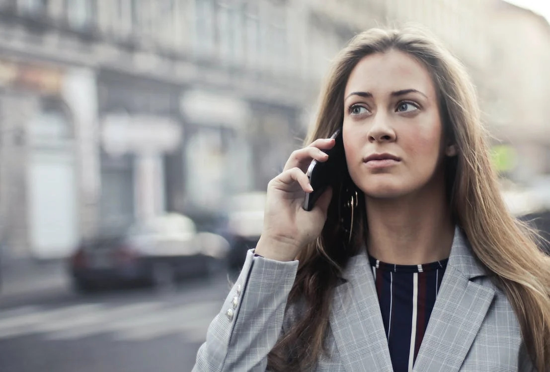 woman in grey suit on a phone call