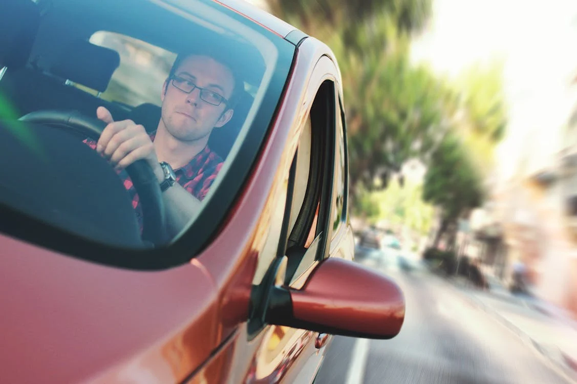 man-driving-red-car man driving red car
