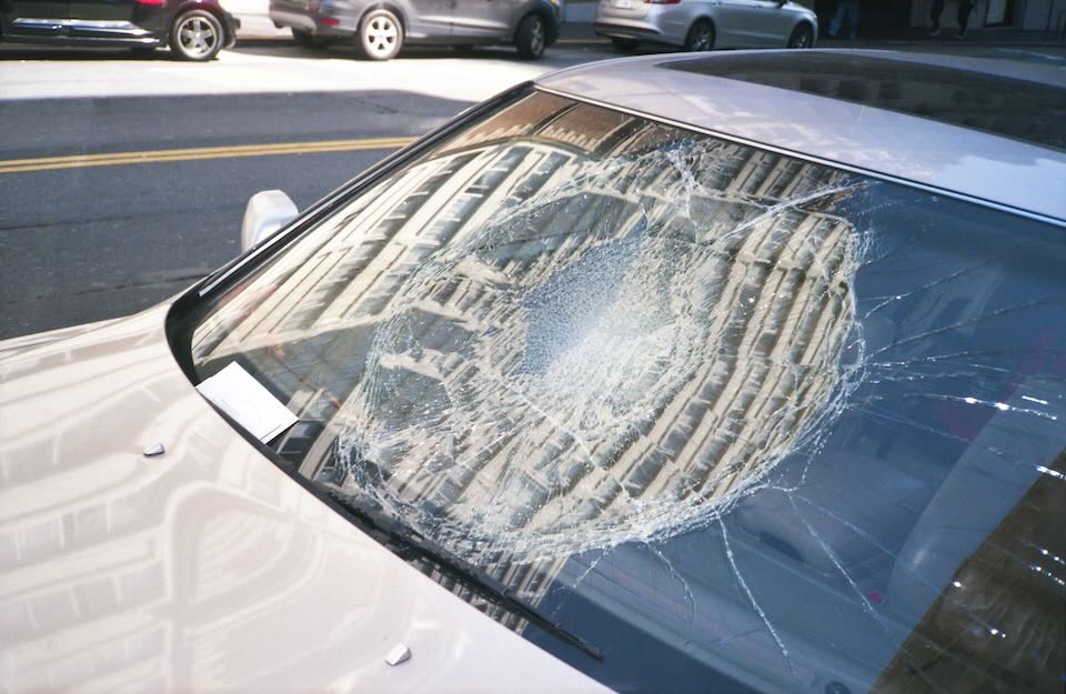 up-close view of damaged car with broken windshield up-close view of damaged car with broken windshield